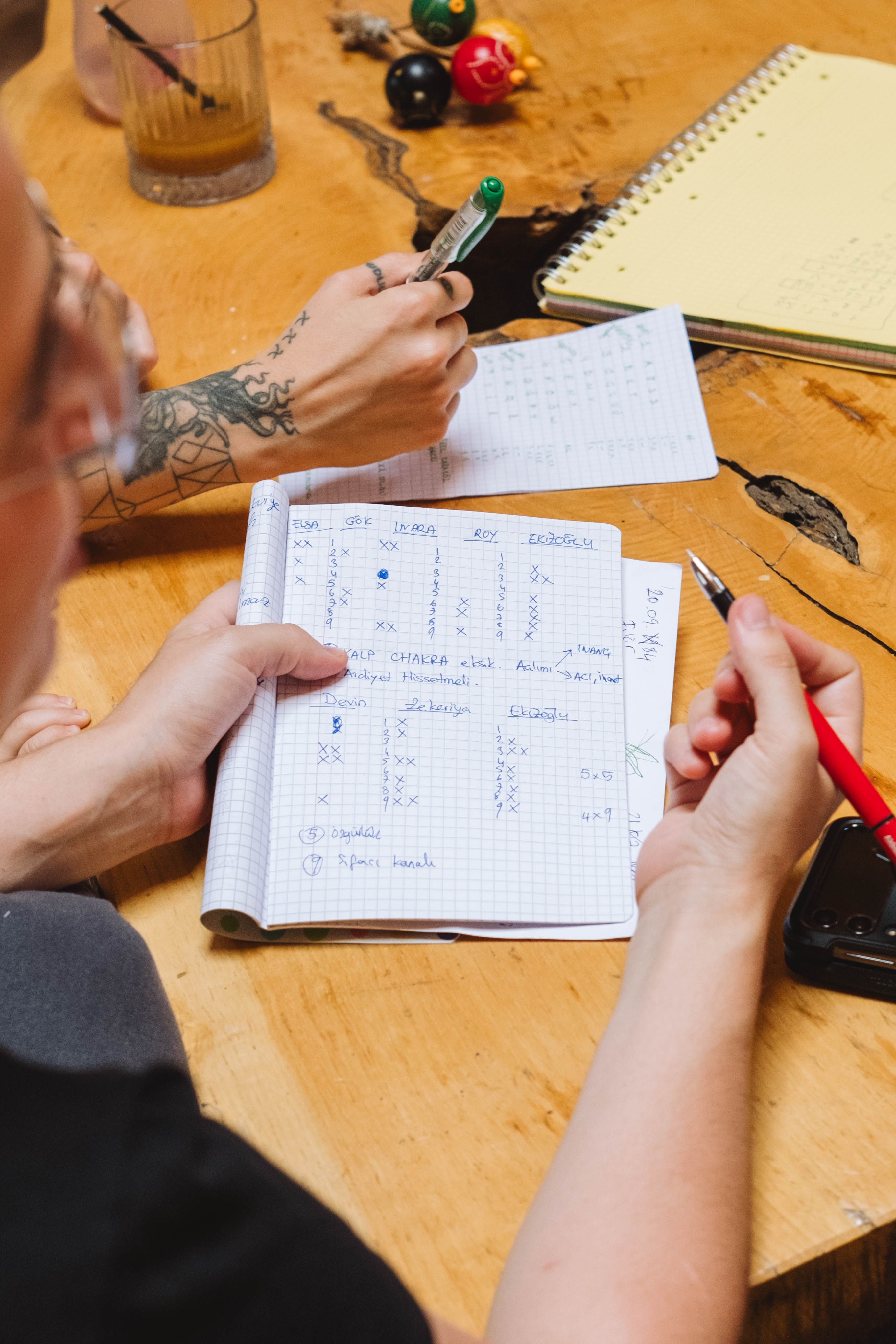 Two people working through plans and notes together at a wooden desk